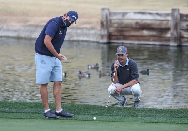 Ngôi sao Phil Mickelson hướng dẫn Donovan gạt bóng golf trên green sân Tây La Quinta