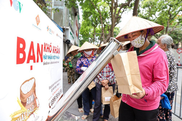 Người dân xếp hàng nhận gạo miễn phí từ cây ATM gạo, đặt tại 58 Quán Sứ, Hà Nội.